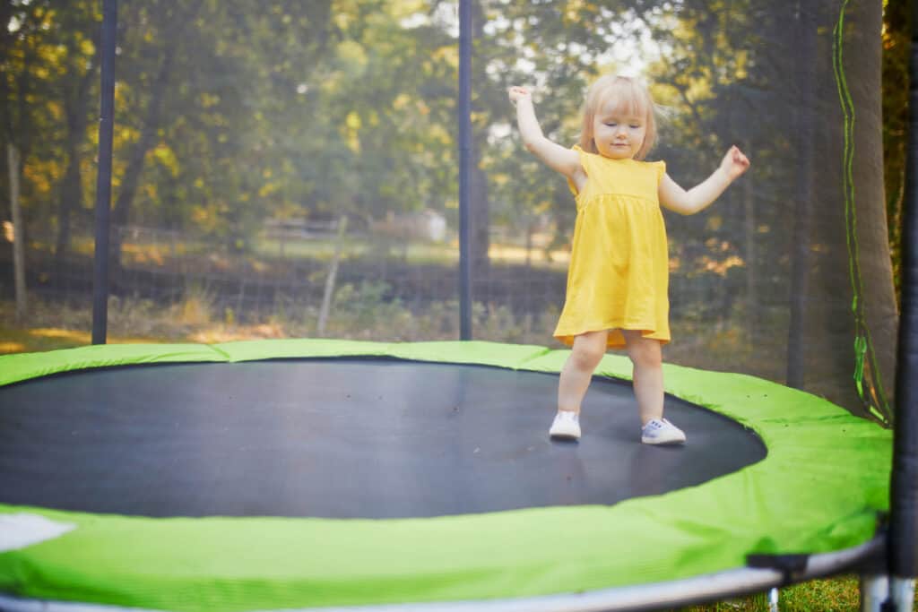 toddler girl having fun on a trampoline Outdoor activities for kids